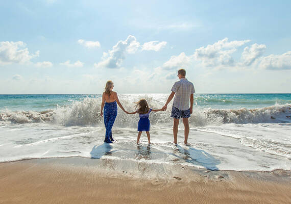 Familia paseando por la orilla del mar en la Costa Dorada